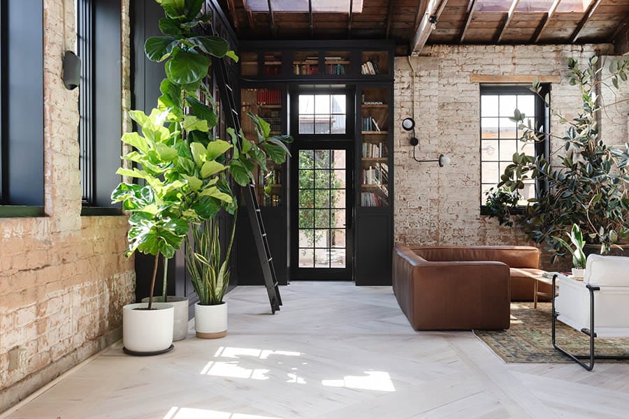 exterior view of older brick home with patio and andersen black framed noise reduction windows