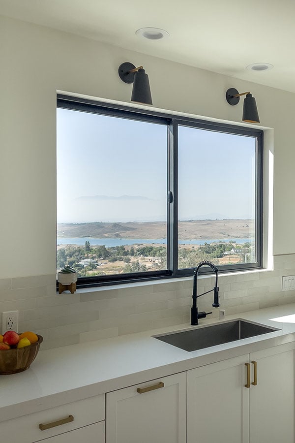 close up view of white kitchen with black framed window