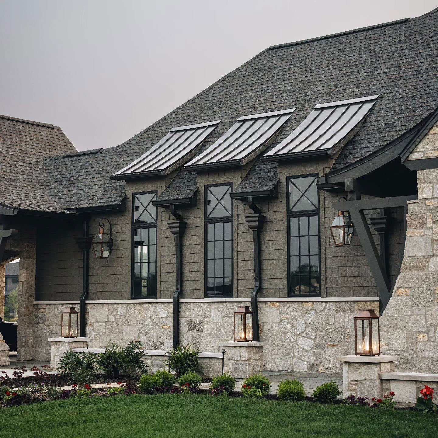 Dark colored victorian home with grille pattern windows and stone