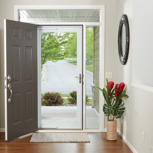 An interior view of an all-glass storm door with a full screen panel letting fresh air and natural light into a home.