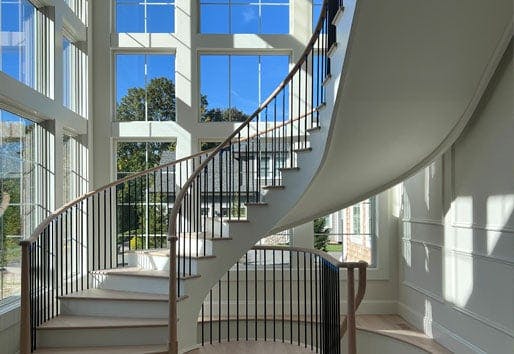 Spiral staircase with floor to ceiling windows with grilles