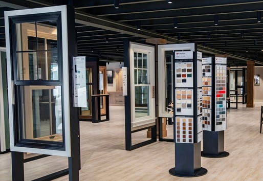 Andersen Windows showroom displaying various products such as double-hung window in black and white and color swatch displays